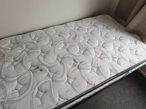 表面可见数处污迹的花纹单人床垫